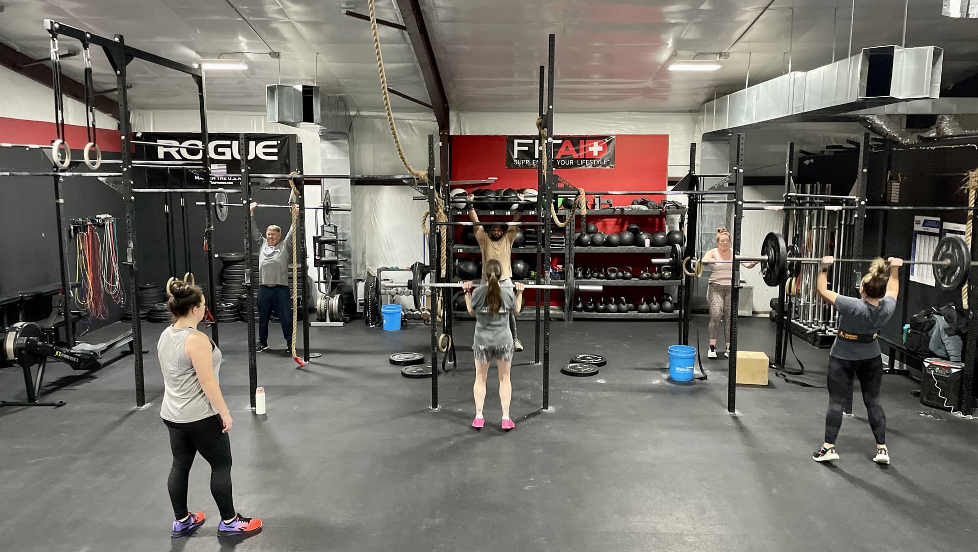Two members high-five in a supportive community gym environment